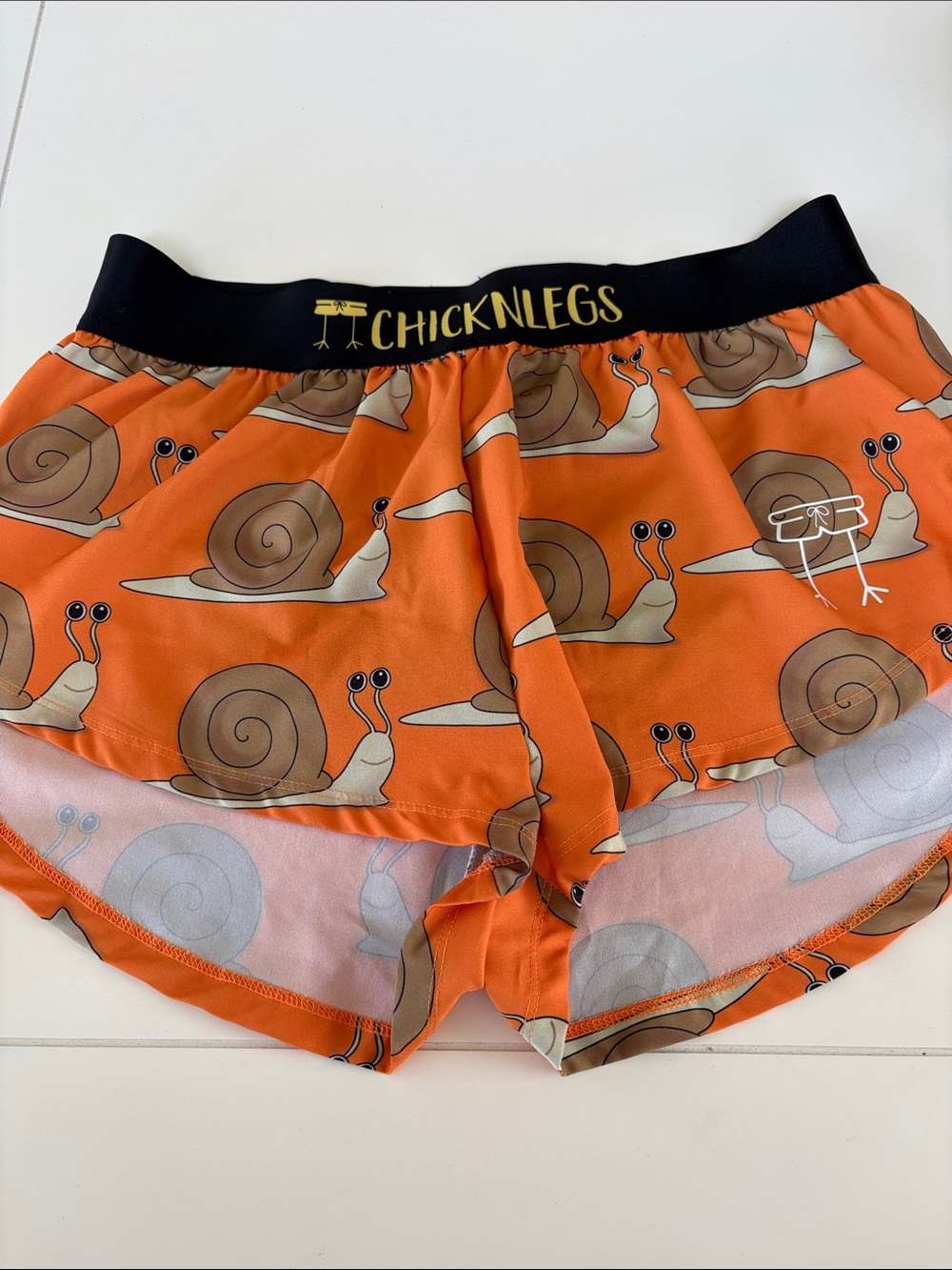 Chickenlegs women’s Orange Snail-Print Running Shorts